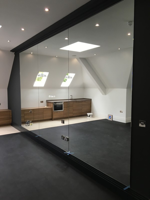 Frameless glass partition in loft conversion by Highbury glaziers